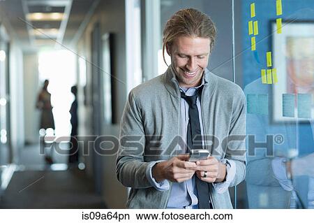 Picture - Businessman using cell phone in office. Fotosearch
