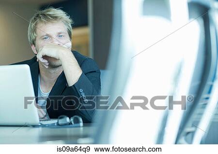 Stock Photo - Businessman using laptop at desk. Fotosearch