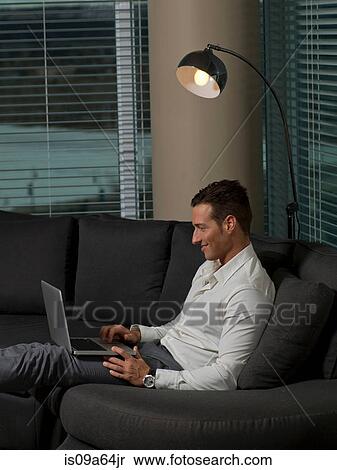 Stock Photography - Businessman using laptop on sofa. Fotosearch