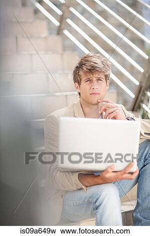 Stock Photo - Businessman using laptop outdoors. Fotosearch