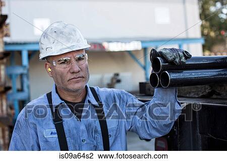 Businessman with pipes in metal plant View Large Photo Image Stock Image - Businessman with pipes in metal plant. Fotosearch