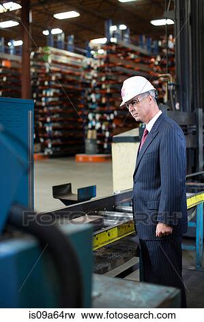 Businessman working in metal plant View Large Photo Image Stock Photo - Businessman working in metal plant. Fotosearch