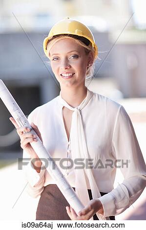 Stock Image - Businesswoman carrying blueprints. Fotosearch