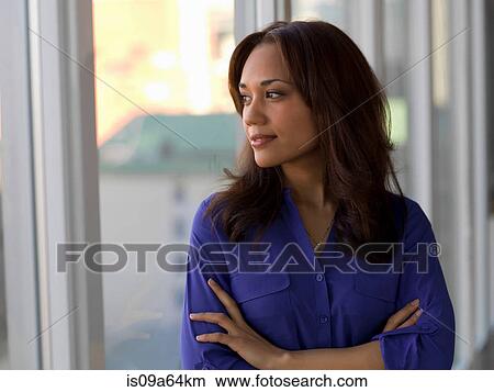 Picture - Businesswoman looking out window. Fotosearch
