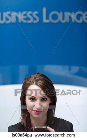 Stock Photograph - Businesswoman relaxing in lounge. Fotosearch