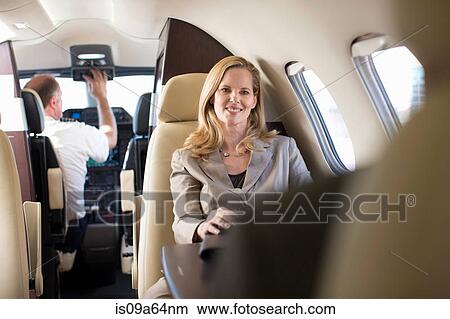 Businesswoman sitting in airplane View Large Photo Image Picture - Businesswoman sitting in airplane. Fotosearch
