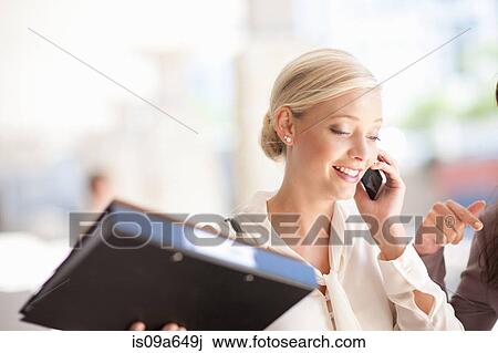 Stock Image - Businesswoman talking on cell phone. Fotosearch