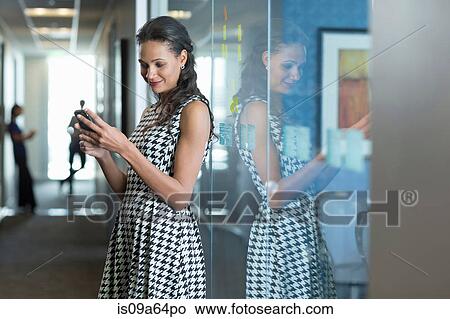 Businesswoman using cell phone in office View Large Photo Image Picture - Businesswoman using cell phone in office. Fotosearch