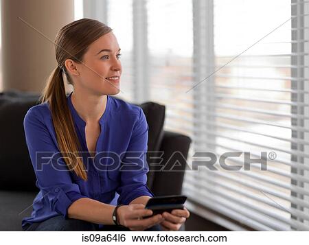 Businesswoman using cell phone on sofa View Large Photo Image Stock Photograph - Businesswoman using cell phone on sofa. Fotosearch