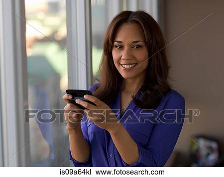 Stock Image - Businesswoman using cell phone. Fotosearch