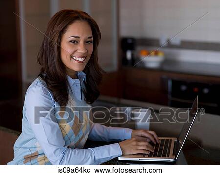 Businesswoman using laptop at counter View Large Photo Image Stock Image - Businesswoman using laptop at counter. Fotosearch