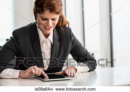 Stock Image - Businesswoman using tablet computer. Fotosearch