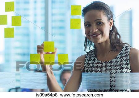 Businesswoman with sticky note on window View Large Photo Image Stock Photo - Businesswoman with sticky note on window. Fotosearch