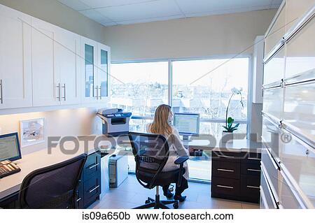 Stock Image - Businesswoman working in office. Fotosearch
