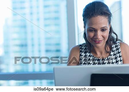 Stock Image - Businesswoman working on laptop. Fotosearch
