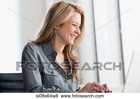 Stock Photo - Businesswoman working on laptop. Fotosearch