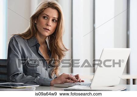 Stock Photo - Businesswoman working on laptop. Fotosearch