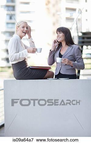 Businesswomen having coffee on balcony View Large Photo Image Stock Photo - Businesswomen having coffee on balcony. Fotosearch