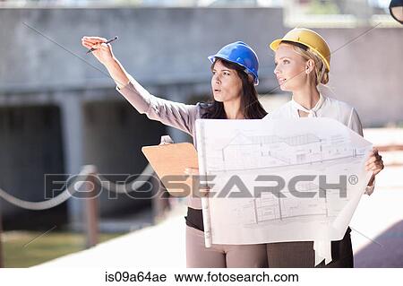 Businesswomen reading blueprints View Large Photo Image Stock Image - Businesswomen reading blueprints. Fotosearch