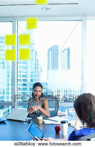 Businesswomen talking at desk View Large Photo Image Stock Photo - Businesswomen talking at desk. Fotosearch