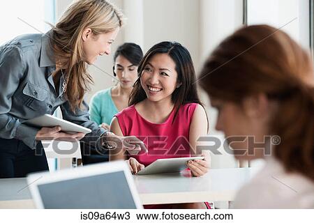Businesswomen talking in office View Large Photo Image Stock Image - Businesswomen talking in office. Fotosearch