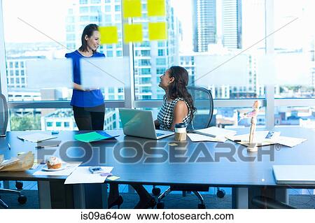 Stock Photo - Businesswomen talking in office. Fotosearch