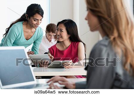 Businesswomen talking in office View Large Photo Image Stock Photography - Businesswomen talking in office. Fotosearch