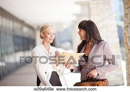 Stock Image - Businesswomen talking in walkway. Fotosearch