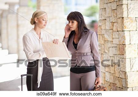 Stock Image - Businesswomen talking in walkway. Fotosearch