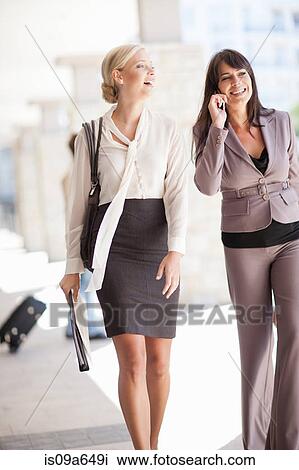 Stock Image - Businesswomen walking together. Fotosearch