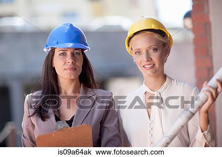 Stock Image - Businesswomen wearing hard hats. Fotosearch