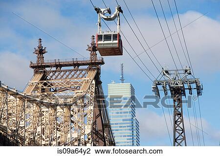 Stock Image - Chairlift over urban bridge. Fotosearch