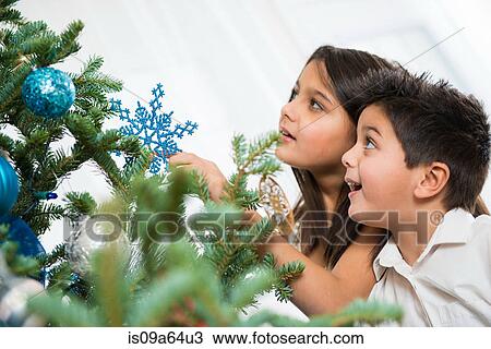 Children decorating Christmas tree View Large Photo Image Stock Image - Children decorating Christmas tree. Fotosearch