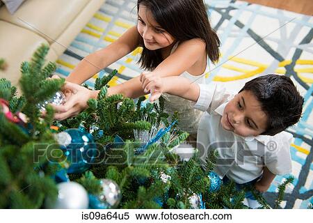 Stock Photography - Children decorating Christmas tree. Fotosearch