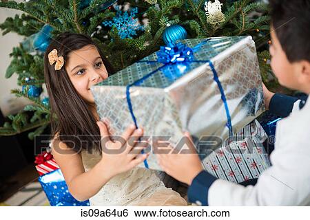 Stock Photograph - Children holding Christmas present. Fotosearch