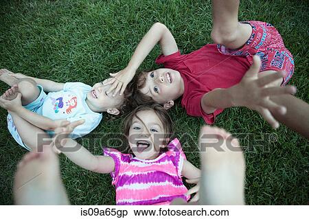 Stock Photography - Children playing in grassy field. Fotosearch