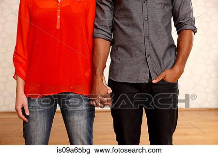 Stock Image - Close up of couple holding hands. Fotosearch