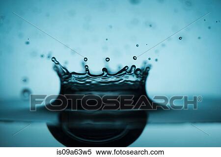 Stock Photography - Close up of drop splashing in water. Fotosearch