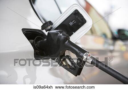 Stock Image - Close up of gas nozzle in tank. Fotosearch
