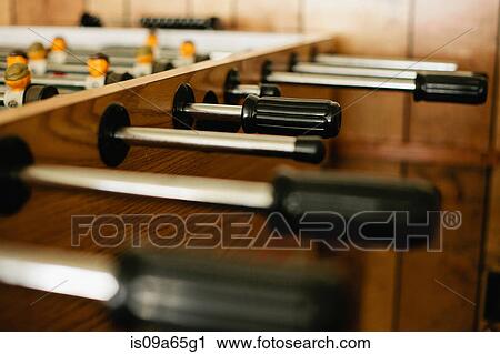 Stock Image - Close up of handles on foosball table. Fotosearch