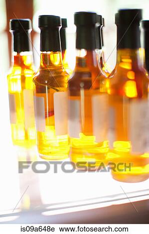 Stock Image - Close up of oil bottles on shelf. Fotosearch
