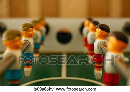 Stock Photo - Close up of players on foosball table. Fotosearch