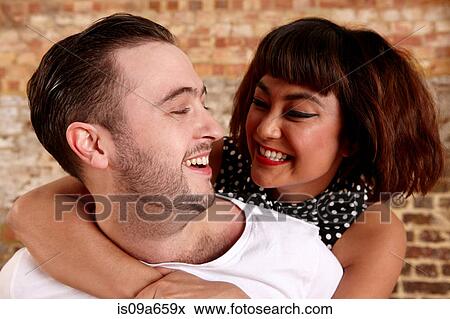 Stock Photo - Close up of smiling couple hugging. Fotosearch
