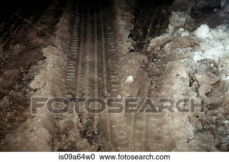 Stock Image - Close up of tire tracks in snow slush. Fotosearch
