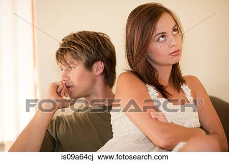 Stock Image - Couple arguing on sofa. Fotosearch