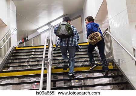 Stock Image - Couple climbing subway steps. Fotosearch