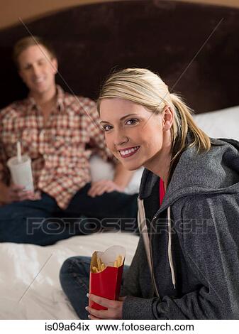 Couple eating fast food on bed View Large Photo Image Stock Photo - Couple eating fast food on bed. Fotosearch