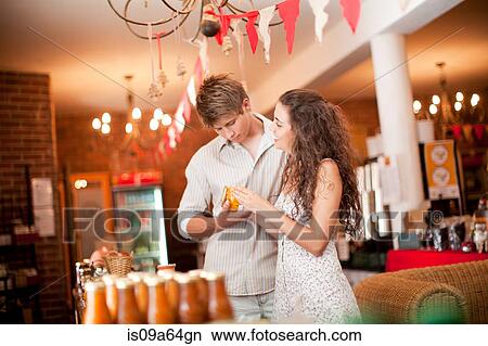 Couple examining preserves in grocery View Large Photo Image Picture - Couple examining preserves in grocery. Fotosearch