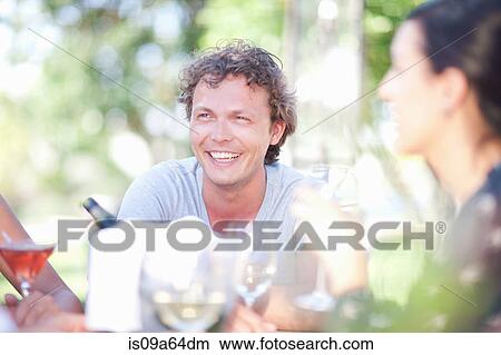 Picture - Couple having drinks together outdoors. Fotosearch