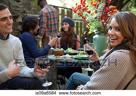 Picture - Couple having wine together outdoors. Fotosearch